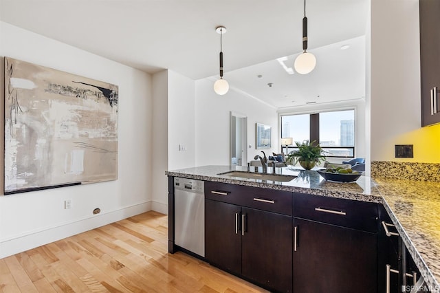 kitchen with sink, light wood-type flooring, decorative light fixtures, stainless steel dishwasher, and light stone counters