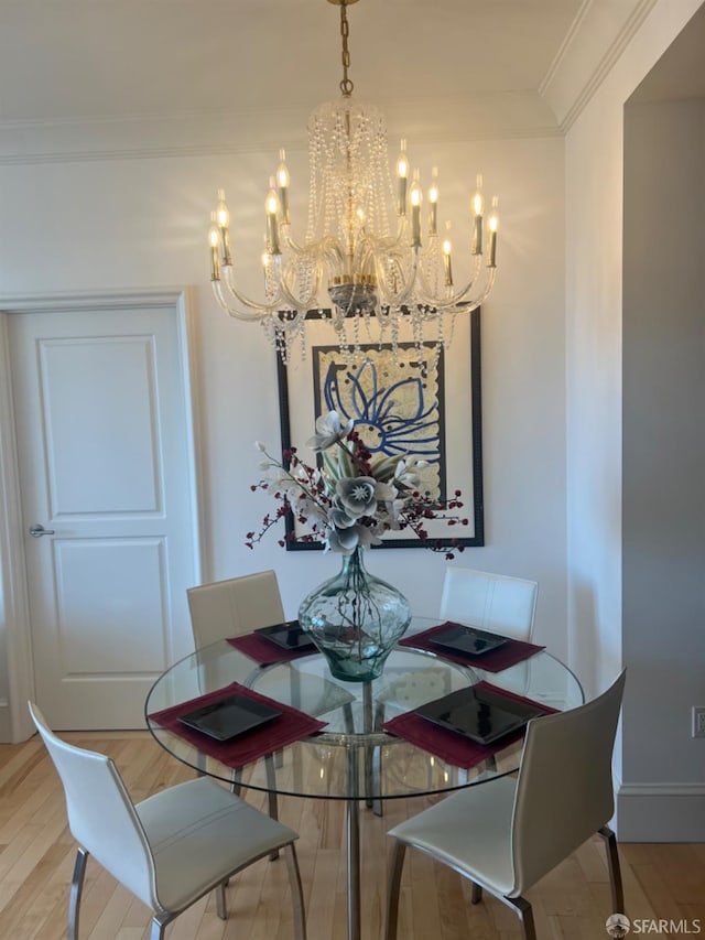 dining space featuring crown molding, a chandelier, and light wood-type flooring