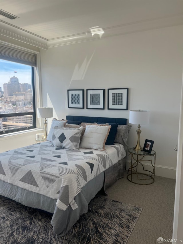 bedroom with ornamental molding and carpet floors