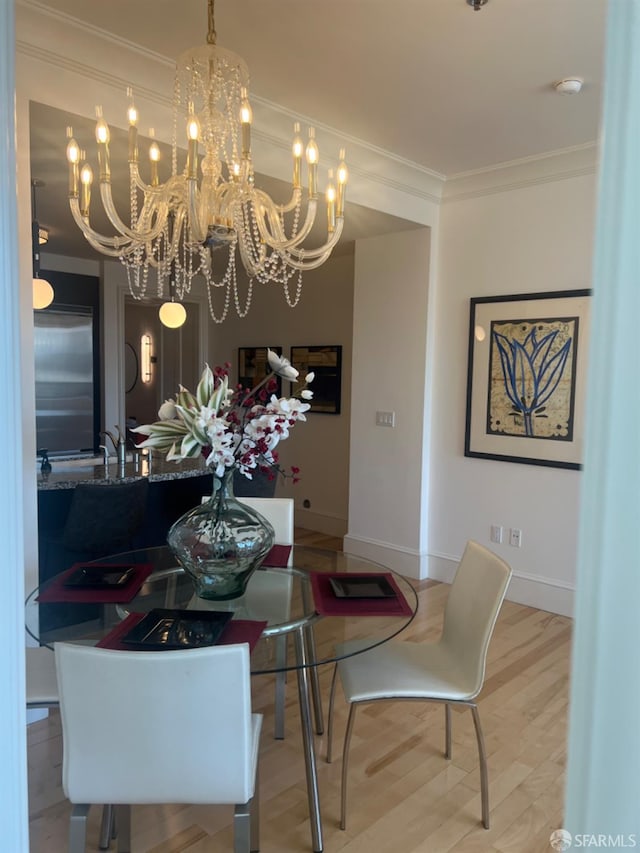 dining space featuring wood-type flooring, ornamental molding, and an inviting chandelier