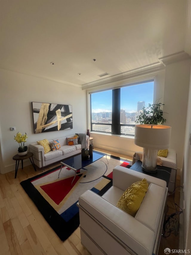 living room featuring crown molding and light hardwood / wood-style flooring