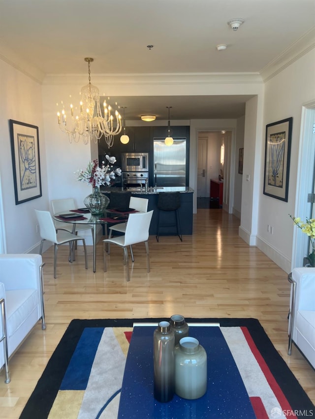 living room featuring light hardwood / wood-style flooring, a chandelier, and crown molding