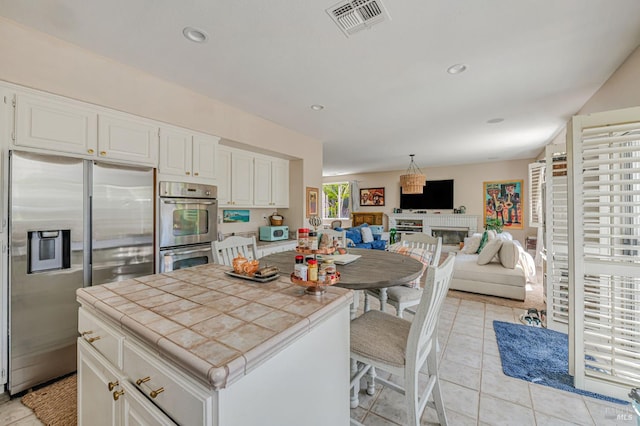 2035 Kirkwood Ct, Fairfield, CA 94534 - kitchen featuring appliances with stainless steel finishes, tile countertops, white cabinets, light tile patterned floors, and open floor plan