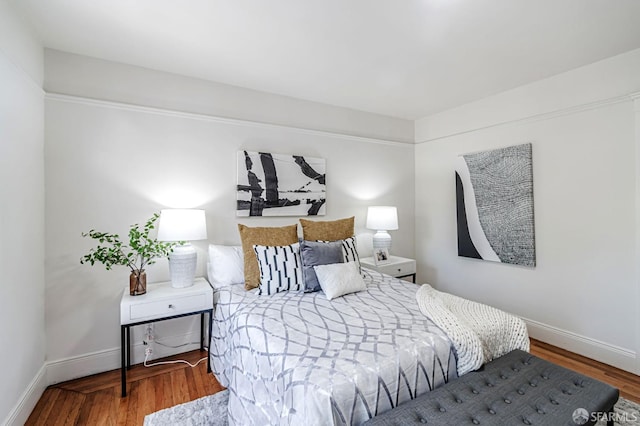 bedroom with baseboards and wood finished floors