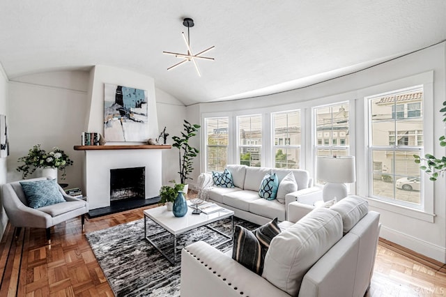 living area with baseboards, a fireplace with raised hearth, and vaulted ceiling