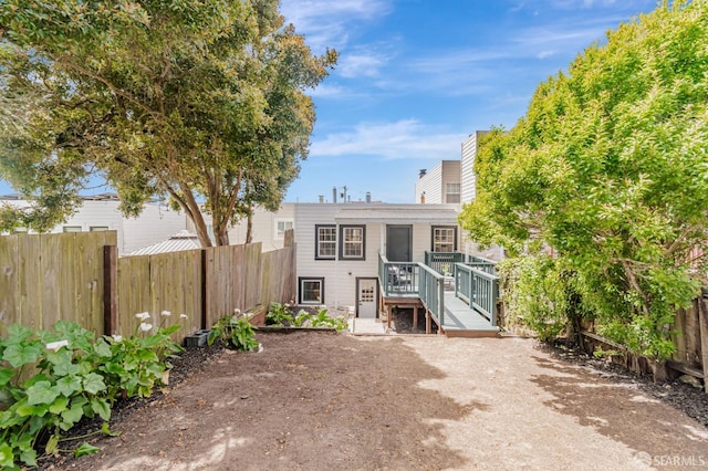back of property featuring a fenced backyard and a wooden deck