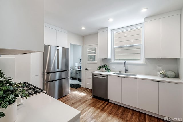 kitchen featuring a sink, light wood-style flooring, appliances with stainless steel finishes, and light countertops