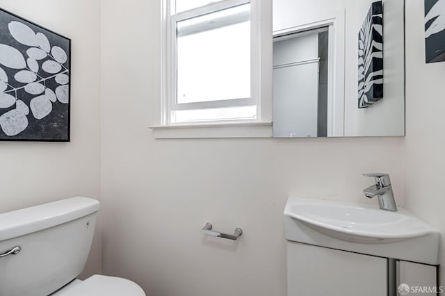 half bathroom with vanity and toilet
