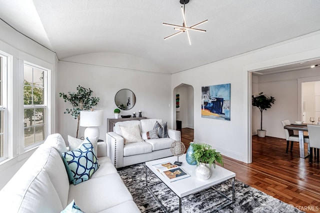 living area with arched walkways, baseboards, and lofted ceiling