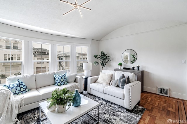 living room with baseboards, lofted ceiling, and visible vents