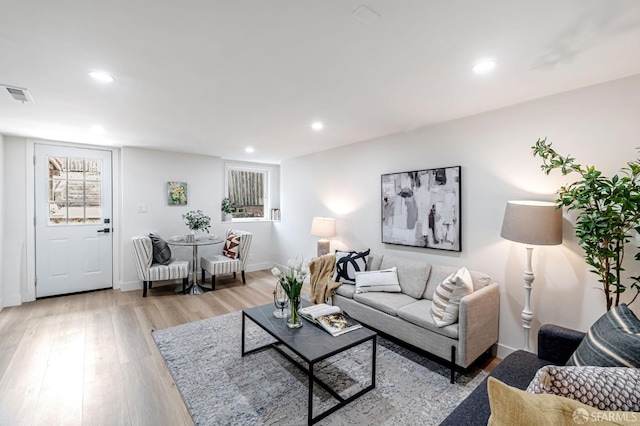 living room with visible vents, recessed lighting, light wood-style floors, and baseboards