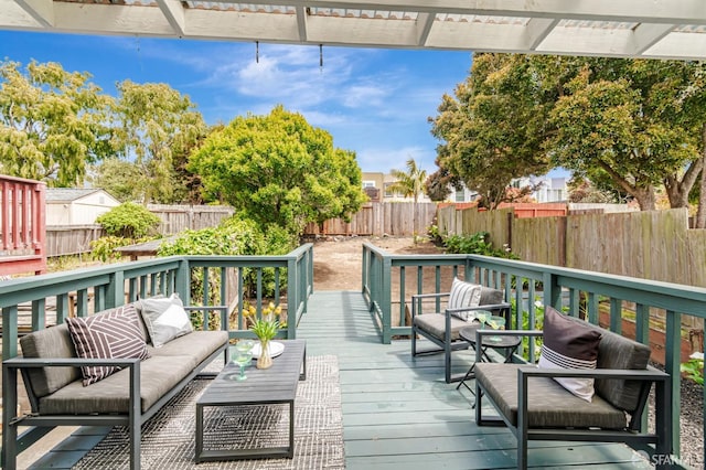 wooden terrace featuring a fenced backyard and an outdoor living space