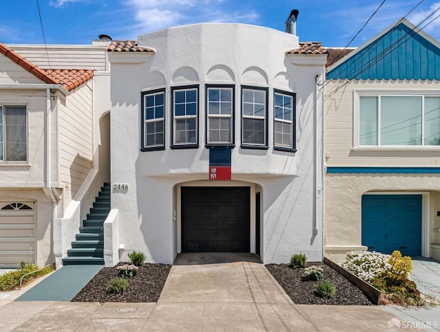 view of front of house with a tiled roof and stucco siding