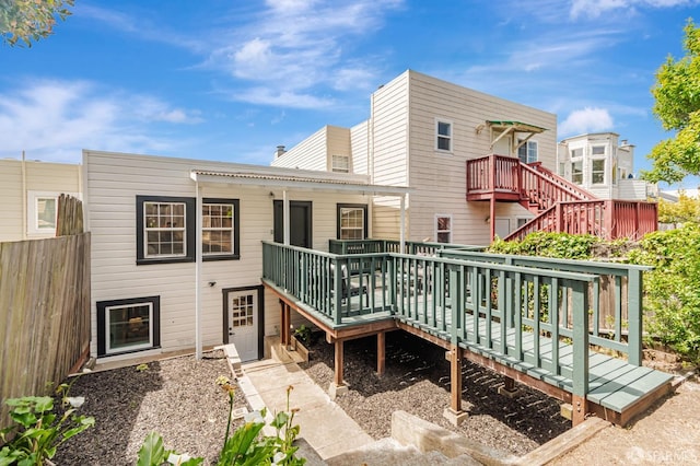 rear view of property featuring stairway and a wooden deck