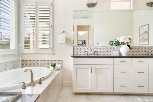 bathroom with vanity, tiled bath, and tile patterned flooring