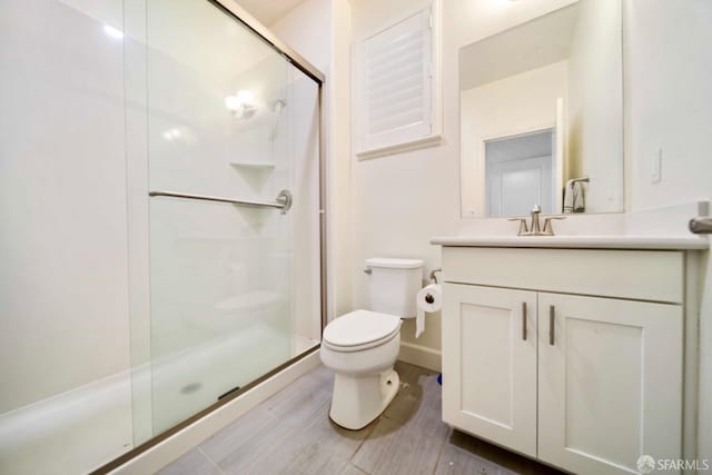 bathroom featuring walk in shower, vanity, and toilet