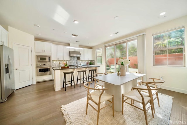 dining space with light hardwood / wood-style floors and sink