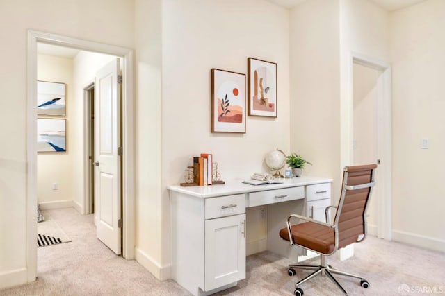 office area with light colored carpet and built in desk