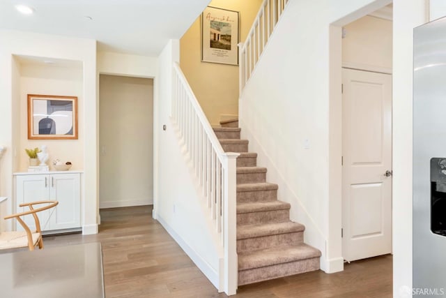 stairs featuring hardwood / wood-style flooring