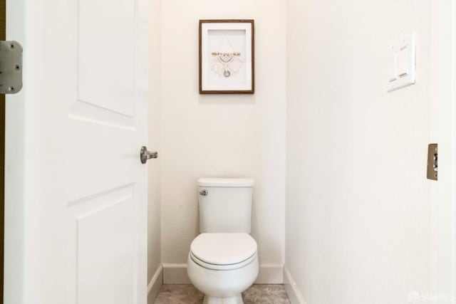 bathroom with toilet and tile patterned flooring