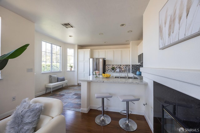 3044 Whisperwave Cir, Redwood City, CA 94065 - kitchen with stainless steel appliances, a peninsula, tasteful backsplash, white cabinets, and light stone counters