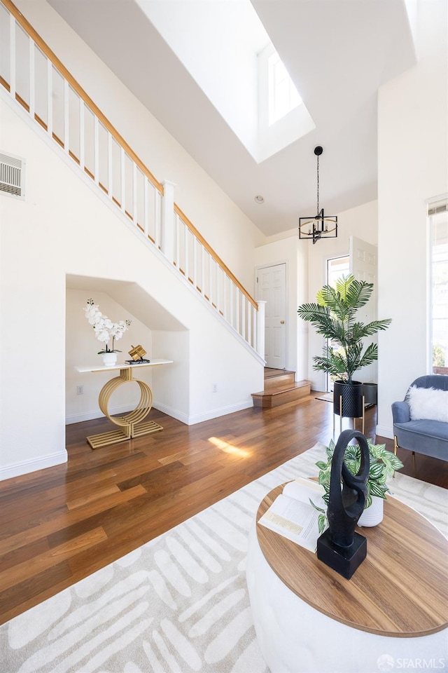 3044 Whisperwave Cir, Redwood City, CA 94065 - living area with a high ceiling, wood finished floors, stairs, a chandelier, and a skylight