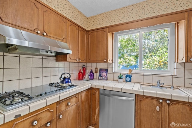532 Vista Ct, Millbrae, CA 94030 - kitchen with appliances with stainless steel finishes, under cabinet range hood, brown cabinetry, backsplash, and a textured ceiling