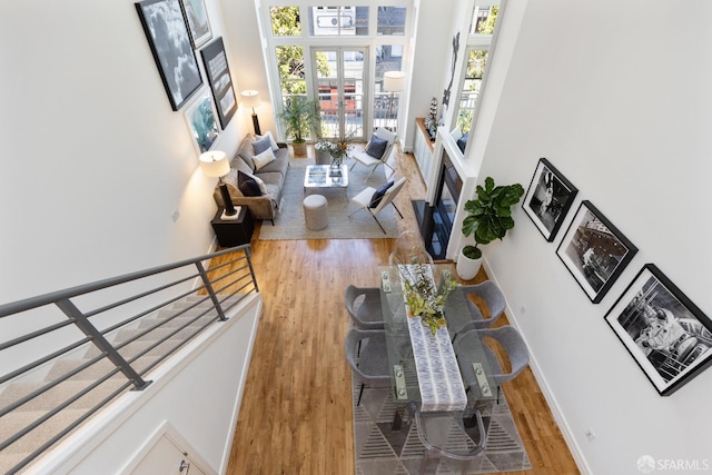 living area featuring baseboards, wood finished floors, and stairs