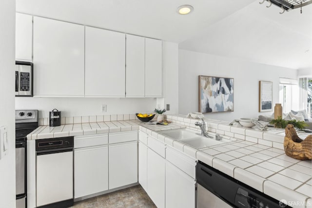 kitchen featuring sink, tile counters, white cabinets, and appliances with stainless steel finishes