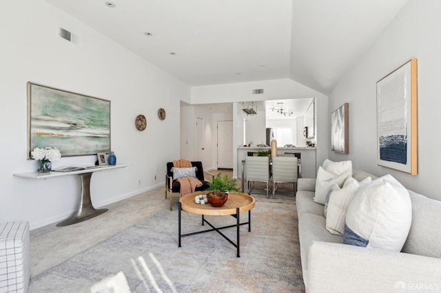 living room featuring lofted ceiling, light colored carpet, and a notable chandelier