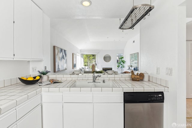 kitchen with sink, tile countertops, dishwasher, and white cabinetry