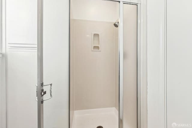 bathroom featuring a shower with door