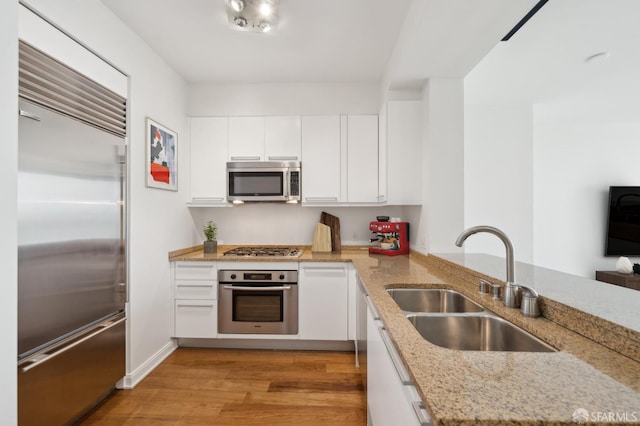 425 1st St Unit 3401, San Francisco, CA 94107 - kitchen featuring stainless steel appliances, a sink, white cabinetry, light wood-style flooring, and a peninsula