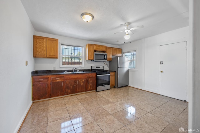 kitchen featuring dark countertops, plenty of natural light, a ceiling fan, and appliances with stainless steel finishes