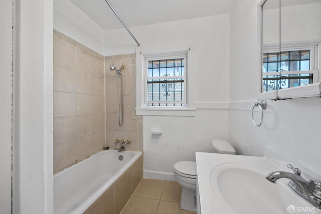 full bath featuring vanity, tile patterned flooring, toilet, tiled shower / bath combo, and baseboards