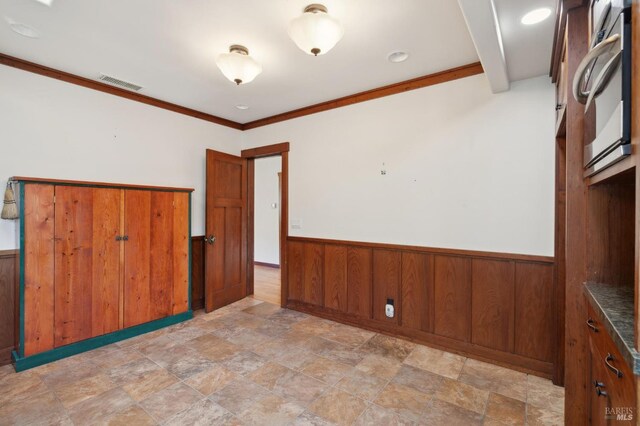 unfurnished room with crown molding and wood walls