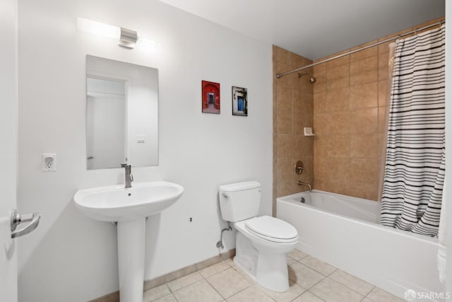 full bathroom with toilet, shower / bath combo with shower curtain, a sink, tile patterned flooring, and baseboards