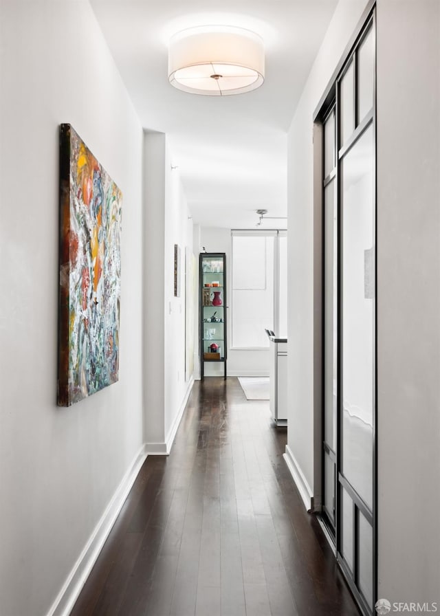 hall featuring dark wood finished floors and baseboards