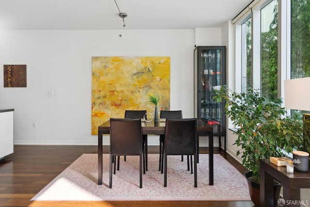 dining space featuring wood finished floors and baseboards