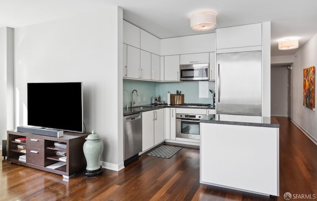 kitchen with appliances with stainless steel finishes, white cabinetry, and a sink