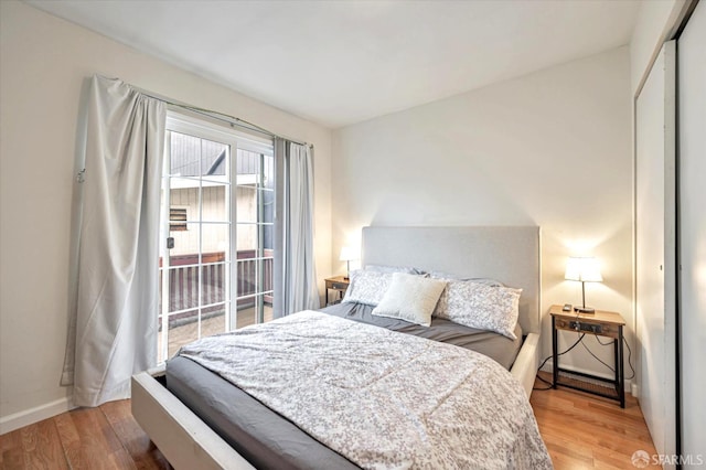 bedroom featuring wood-type flooring, a closet, and access to outside