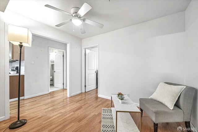 living area featuring ceiling fan and light hardwood / wood-style flooring