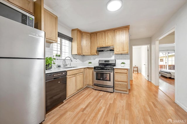 kitchen featuring light brown cabinetry, sink, decorative backsplash, light hardwood / wood-style floors, and stainless steel appliances