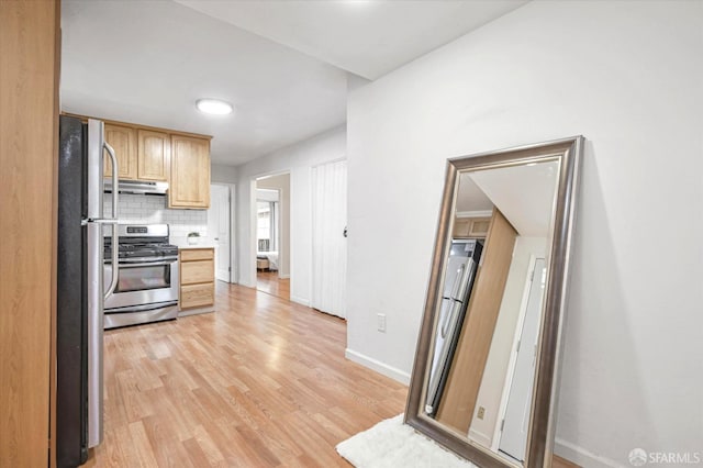 kitchen featuring tasteful backsplash, stainless steel appliances, light brown cabinetry, and light hardwood / wood-style floors