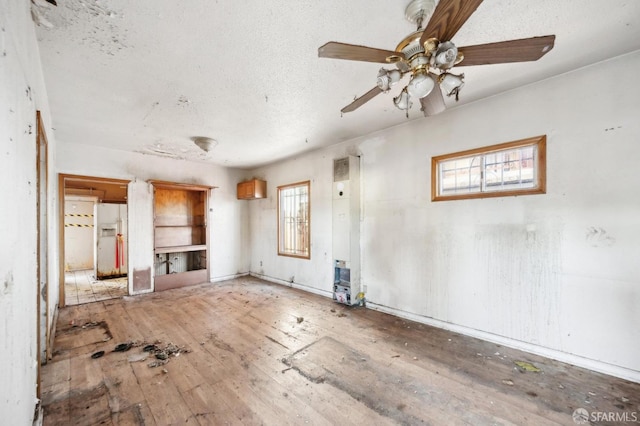 unfurnished living room featuring ceiling fan and hardwood / wood-style flooring