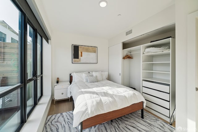 bedroom with wood-type flooring and a closet