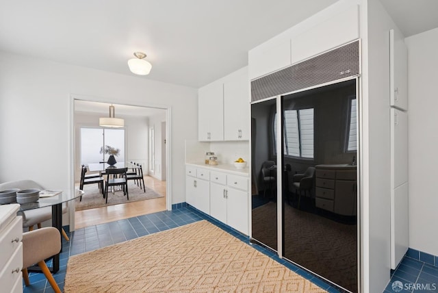 1867 15th Ave, San Francisco, CA 94122 - kitchen featuring black refrigerator, white cabinets, light countertops, dark tile patterned flooring, and a desk