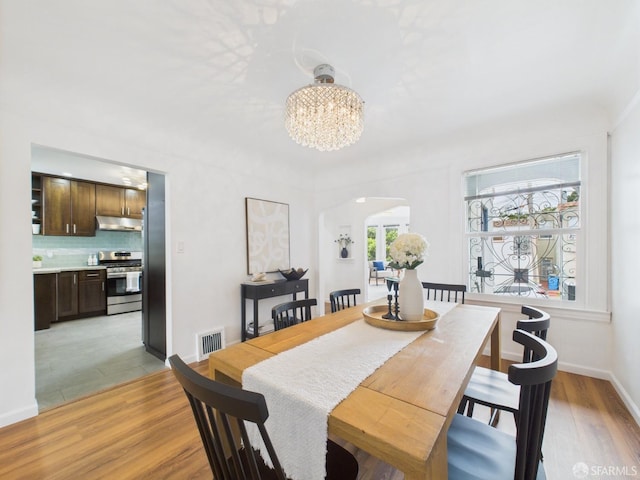 65 Danton St, San Francisco, CA 94112 - dining area with arched walkways, a chandelier, and light wood-style floors