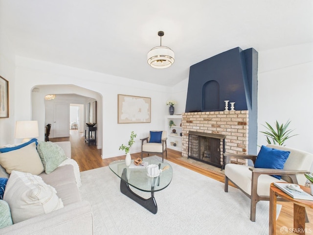 65 Danton St, San Francisco, CA 94112 - living room with arched walkways, wood finished floors, a fireplace, vaulted ceiling, and built in features