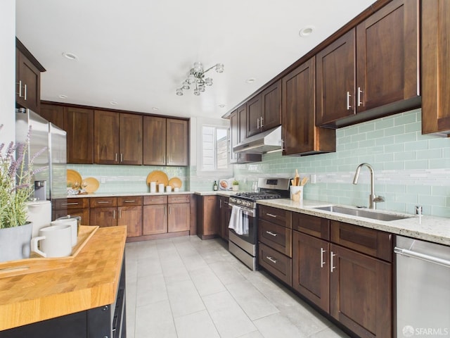 65 Danton St, San Francisco, CA 94112 - kitchen featuring stainless steel appliances, under cabinet range hood, tasteful backsplash, light tile patterned floors, and light stone countertops